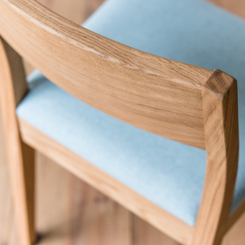 Shaped back support of the Brampton upholstered chair in prime oak with clear oiled finish