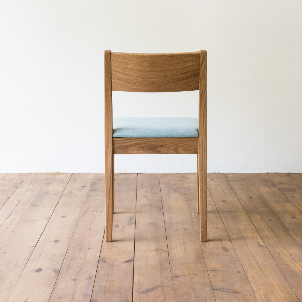 rear view of orpago hand made bespoke brampton kitchen dining lowback chair made from oak and a clear oiled finish with an upholstered seat and seat cushion