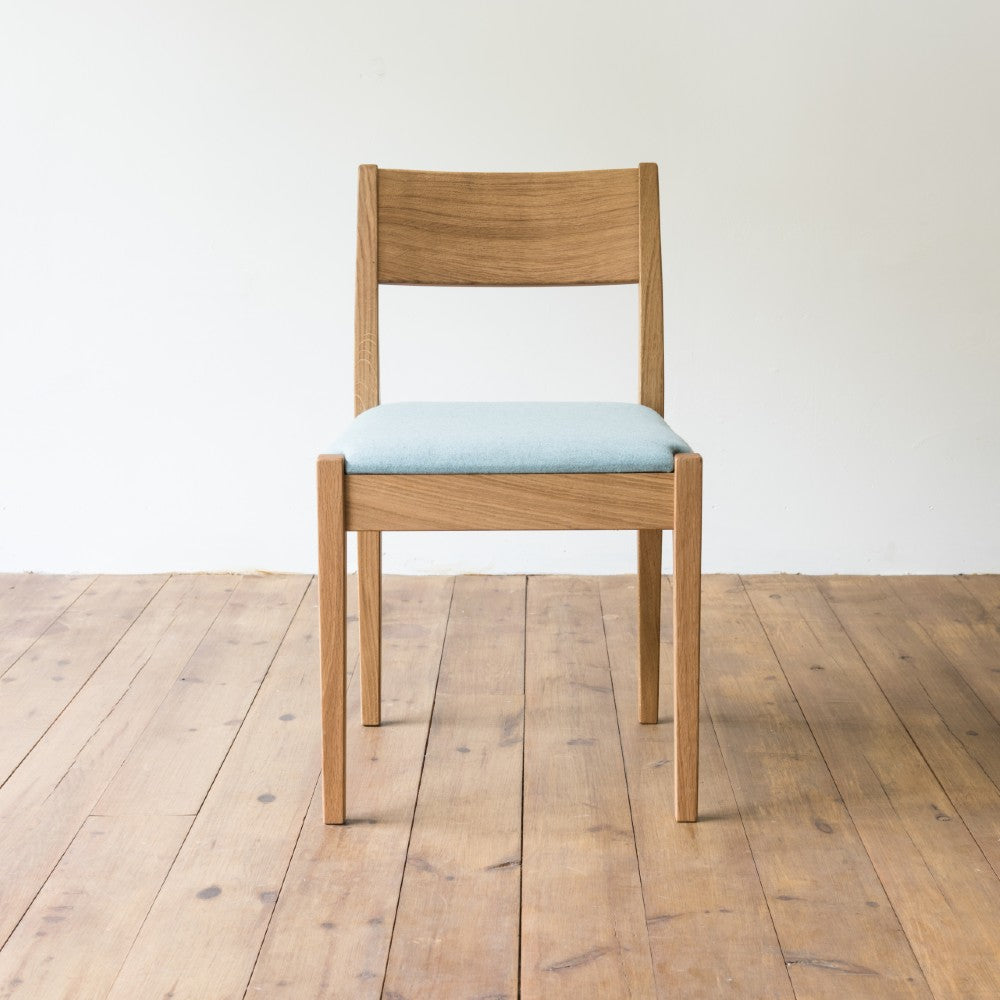 front view of orpago hand made bespoke brampton kitchen dining lowback chair made from oak and a clear oiled finish with an upholstered seat and seat cushion