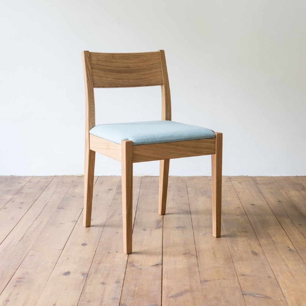 front right and side view of orpago hand made bespoke brampton kitchen dining lowback chair made from oak and a clear oiled finish with an upholstered seat and seat cushion